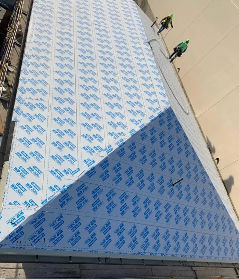 Professional roofers installing underlayment on a metal roof in Joliet